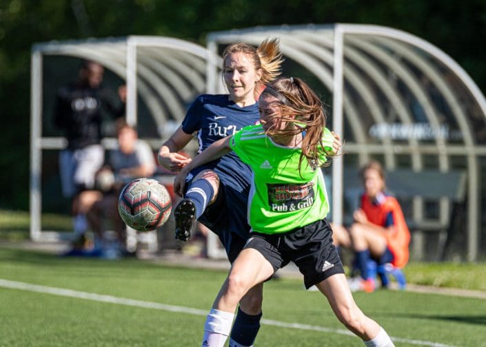 OAKVILLE, ON - JUN. 23, 2019: Players battle for the ball during a League1 Ontario women's soccer game between the Oakville Blue Devils and DeRo United.